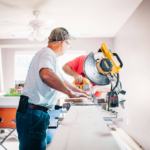 Two men work on home repairs before selling the house