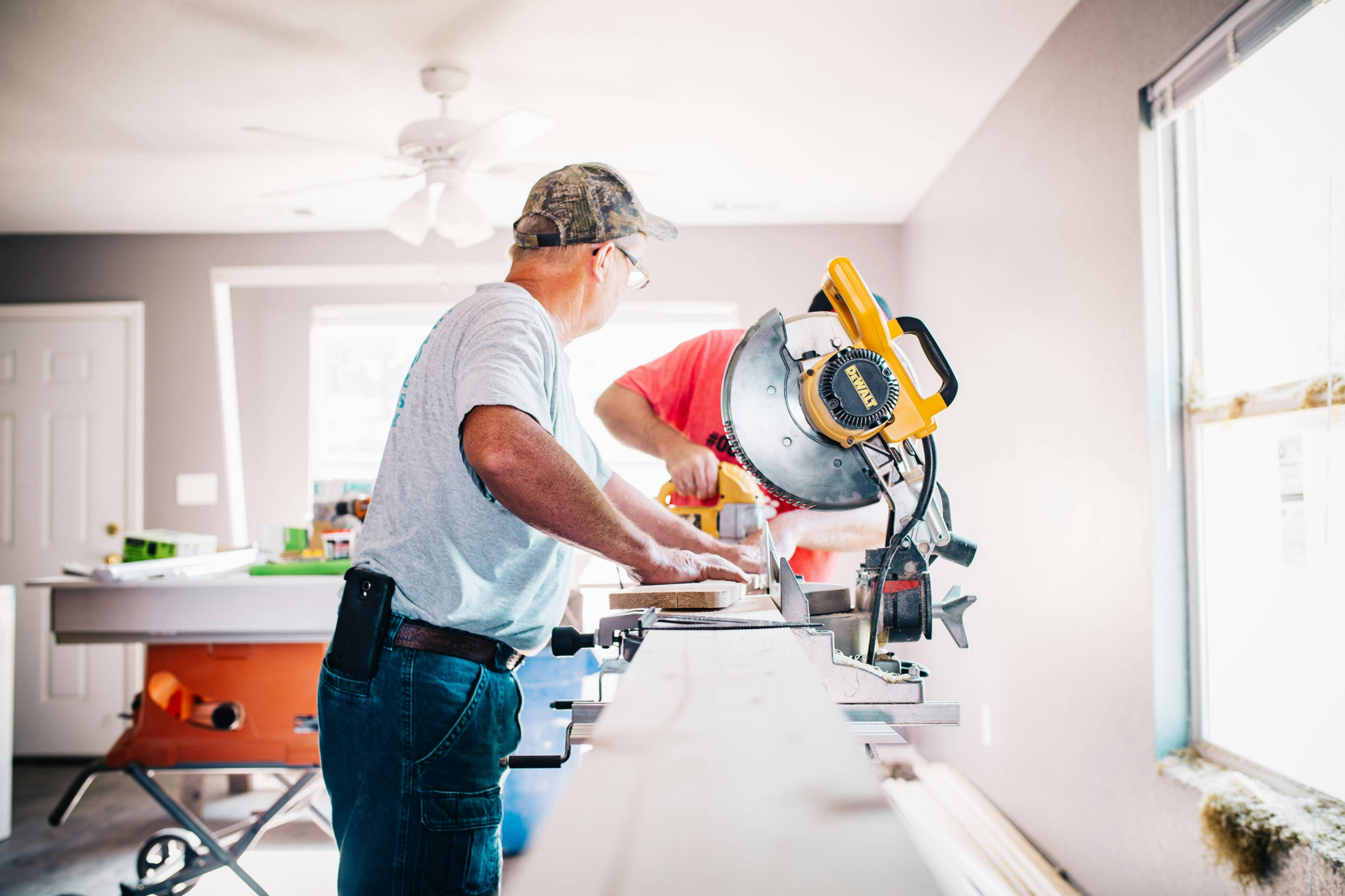 Two men work on home repairs before selling the house
