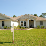 A “For Sale” on the lawn in front of a one-story home