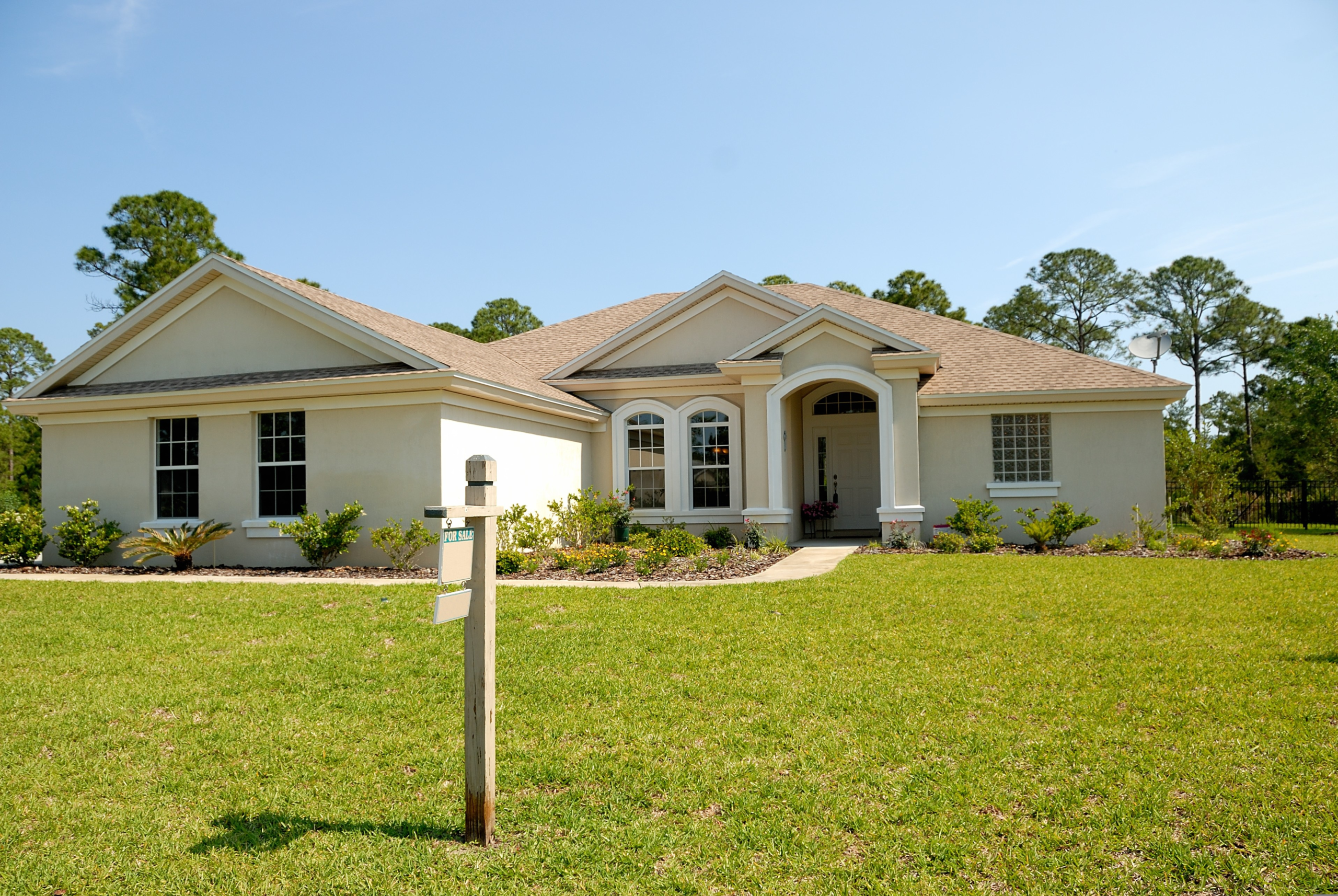 A βFor Saleβ on the lawn in front of a one-story home